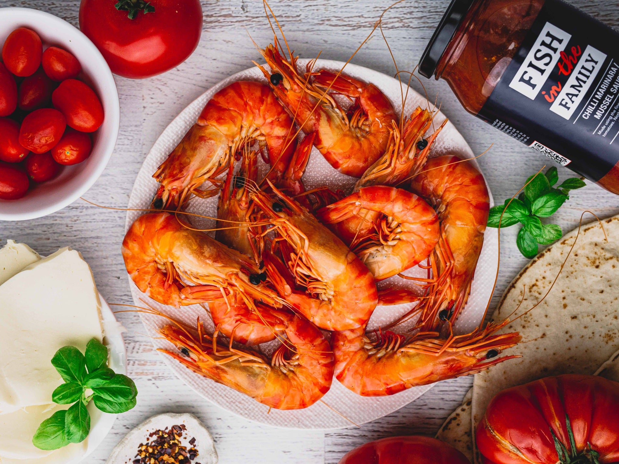 A plate of fresh cooked prawns surrounded by accompaniments