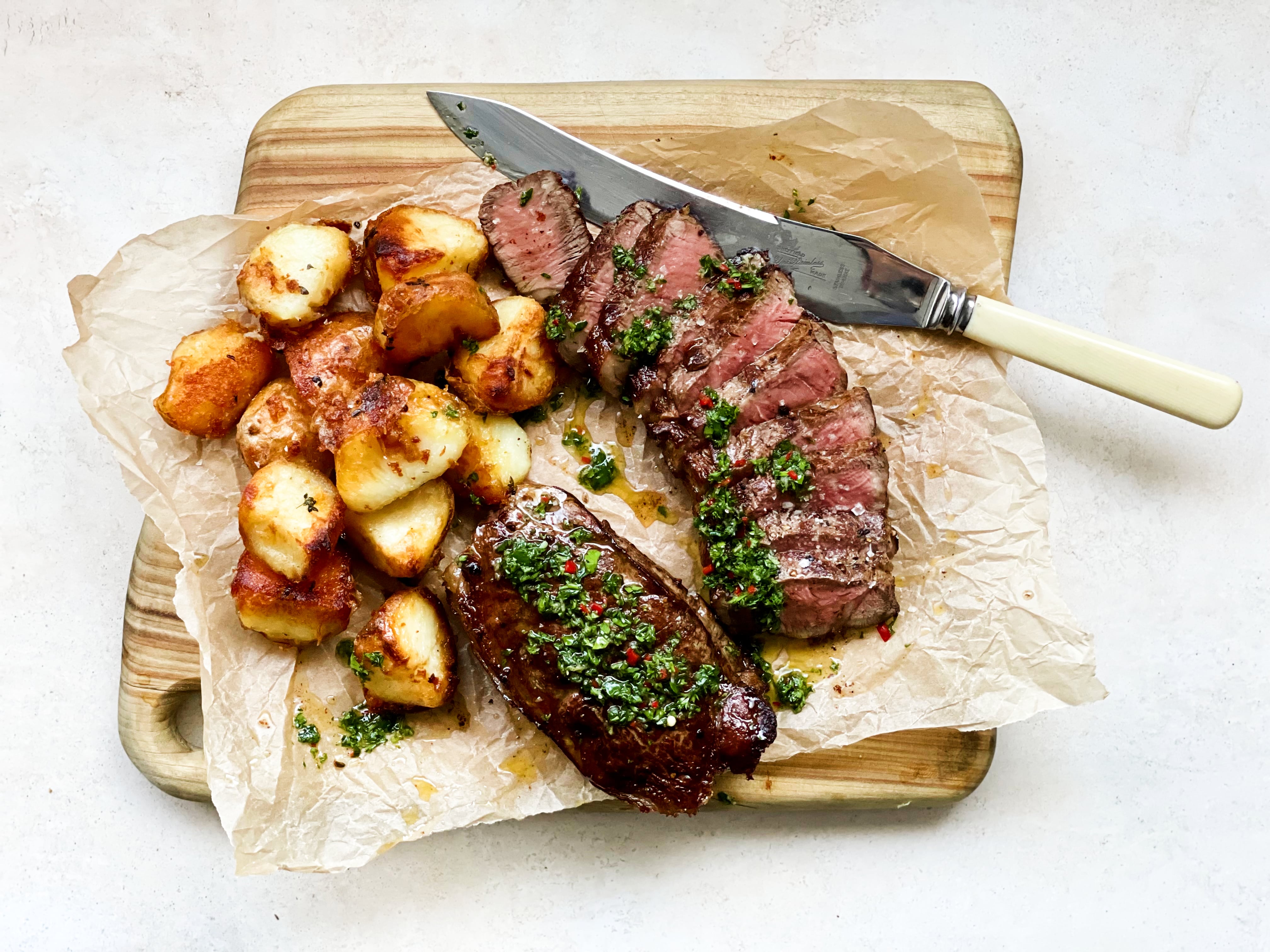 Roasted potatoes with roasted sliced scotch fillet steak topped with chimichurri