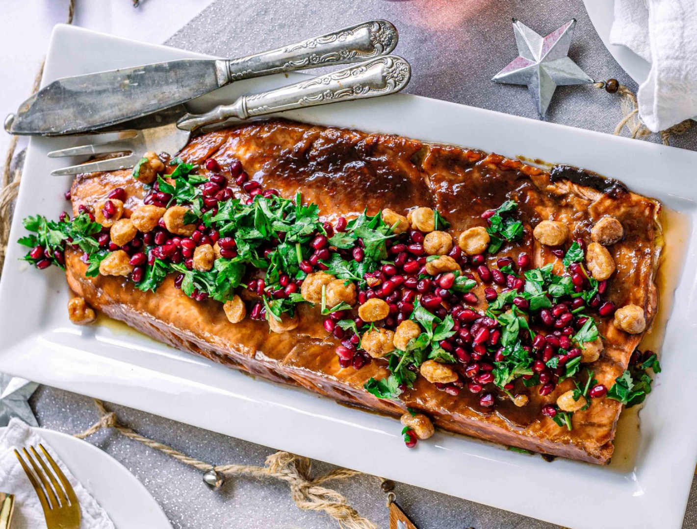 A whole side of baked salmon topped with pomegranate seeds and honeyed macadamia nuts