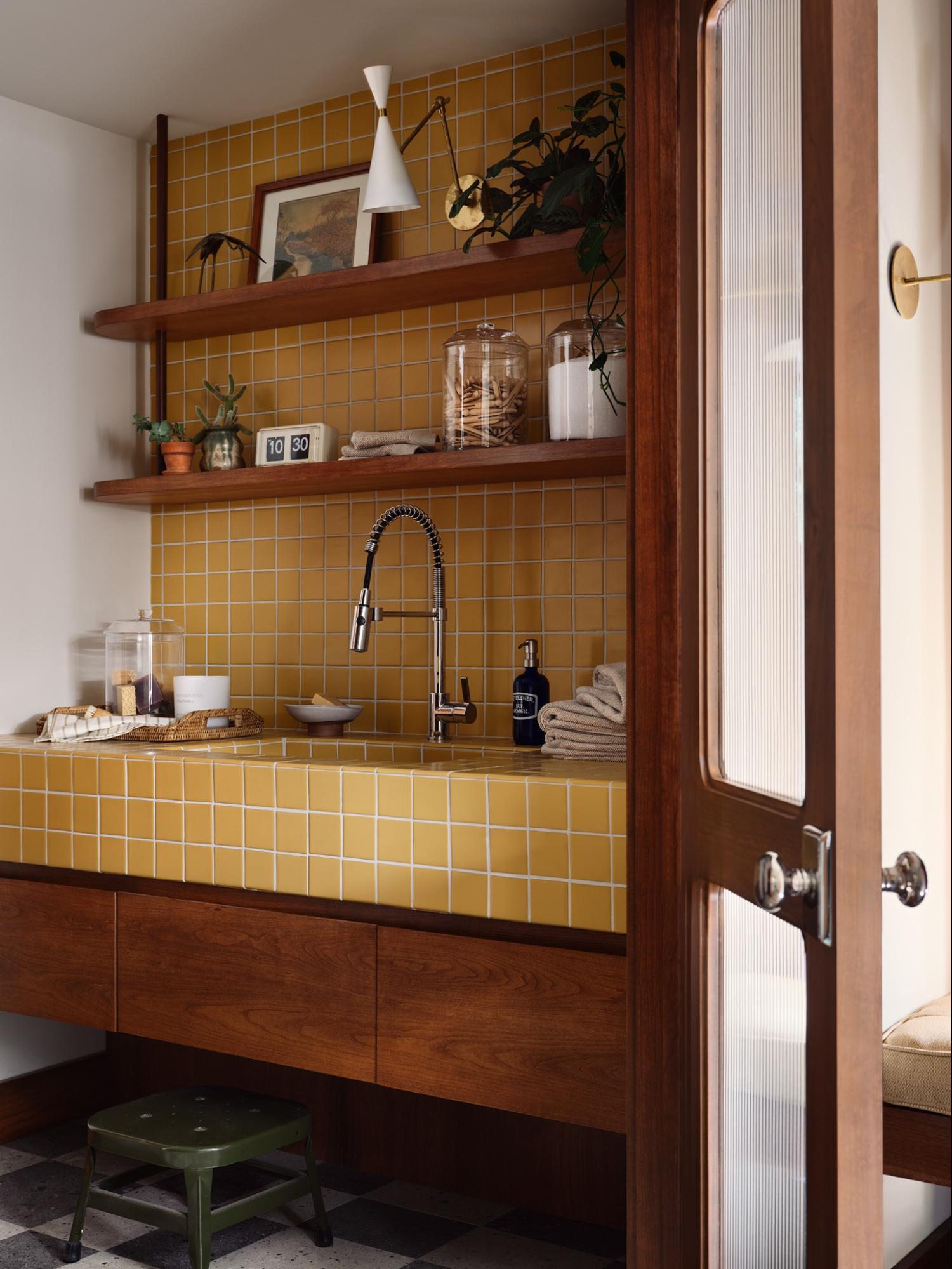 The laundry room in Fixer Upper: The Lakehouse features yellow tile, warm millwork, a washer and dryer, and more.