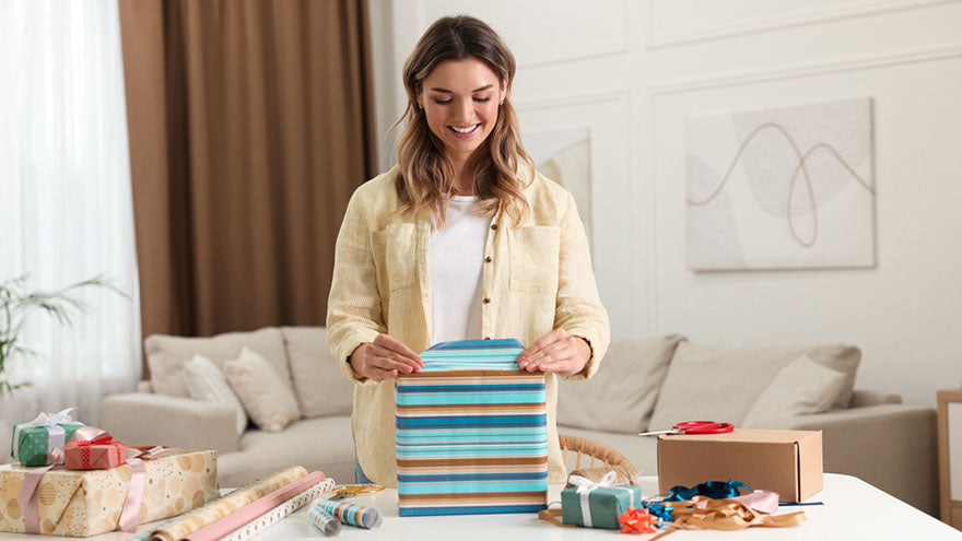 woman wrapping box in home