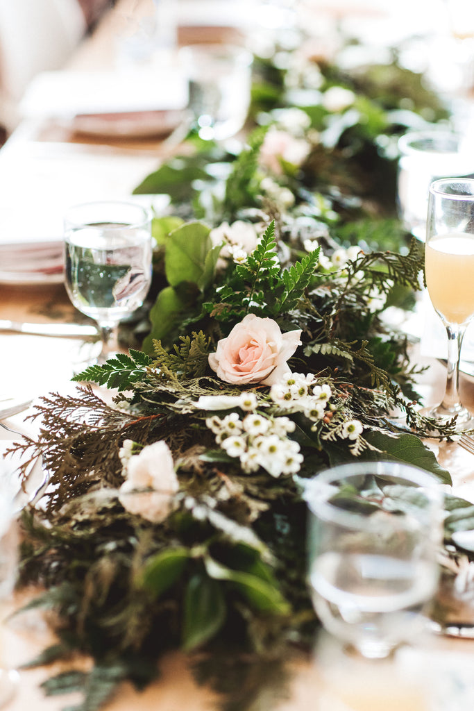 Table with floral garland by Erie Way Flowers