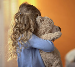 Little girl hugging stuffed bear