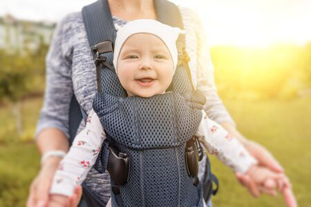happy baby in baby carrier