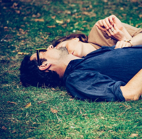 man and woman sleeping on the grass