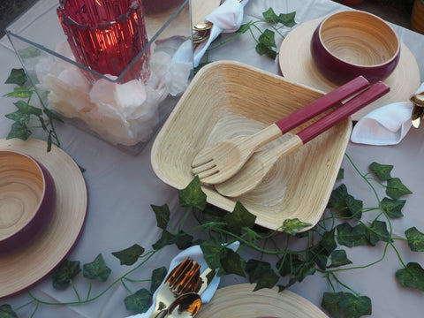 A table laid with bamboo crockery, brass cutlery and ivy