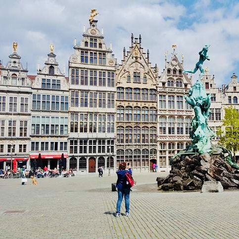a woman in a private tour with tulip day tours takes a picture of Brabo on the market square of Antwerp
