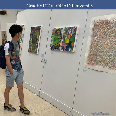 man looking at paintings by Rachael Grad at GradEx 107 in OCAD University