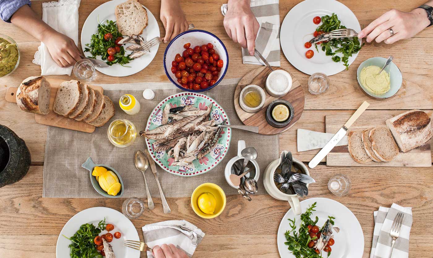 table set for lunch with mackerel and salads