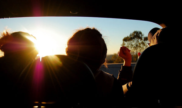 A group of friends watching the sunset in a car