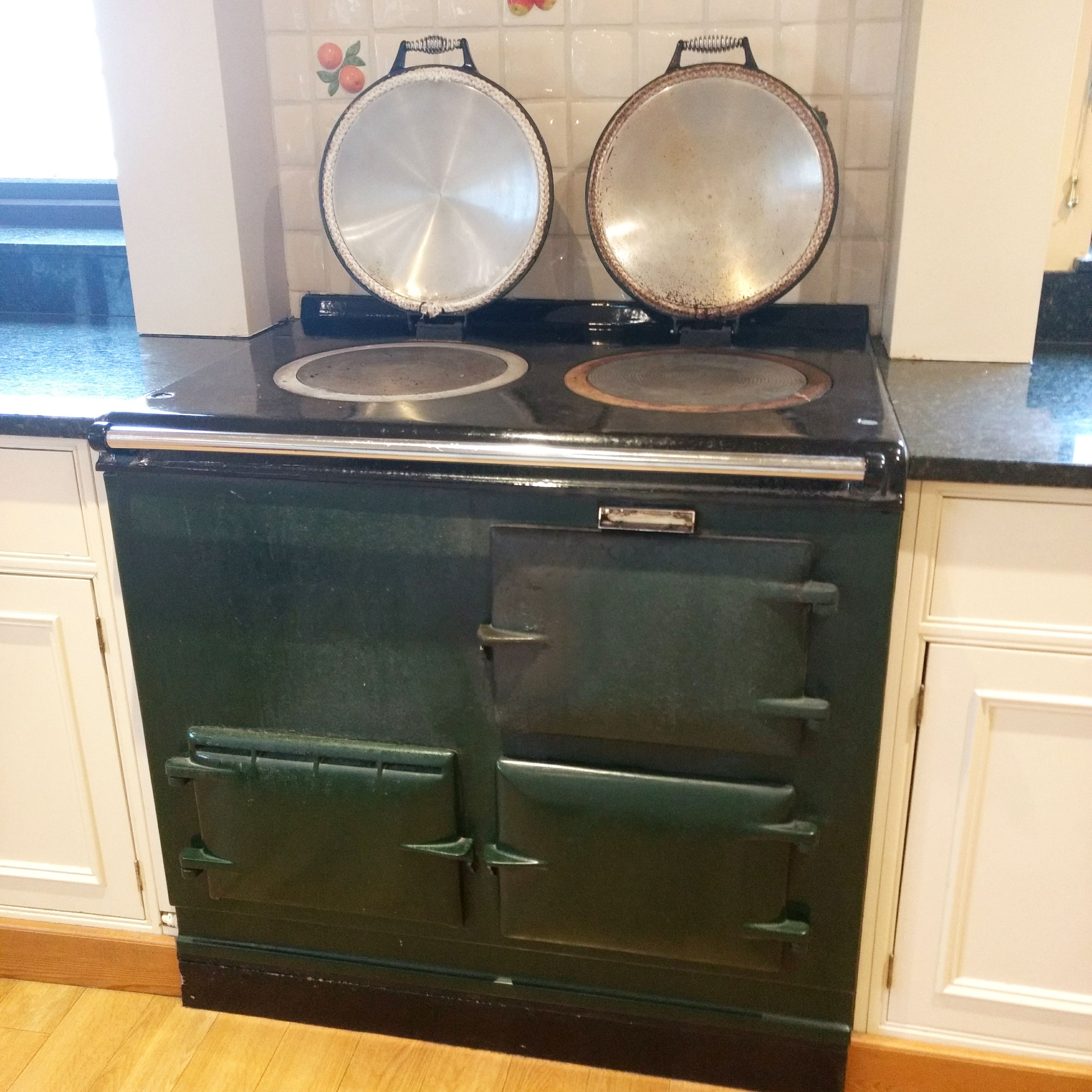 Aga range cooker with lids up in green