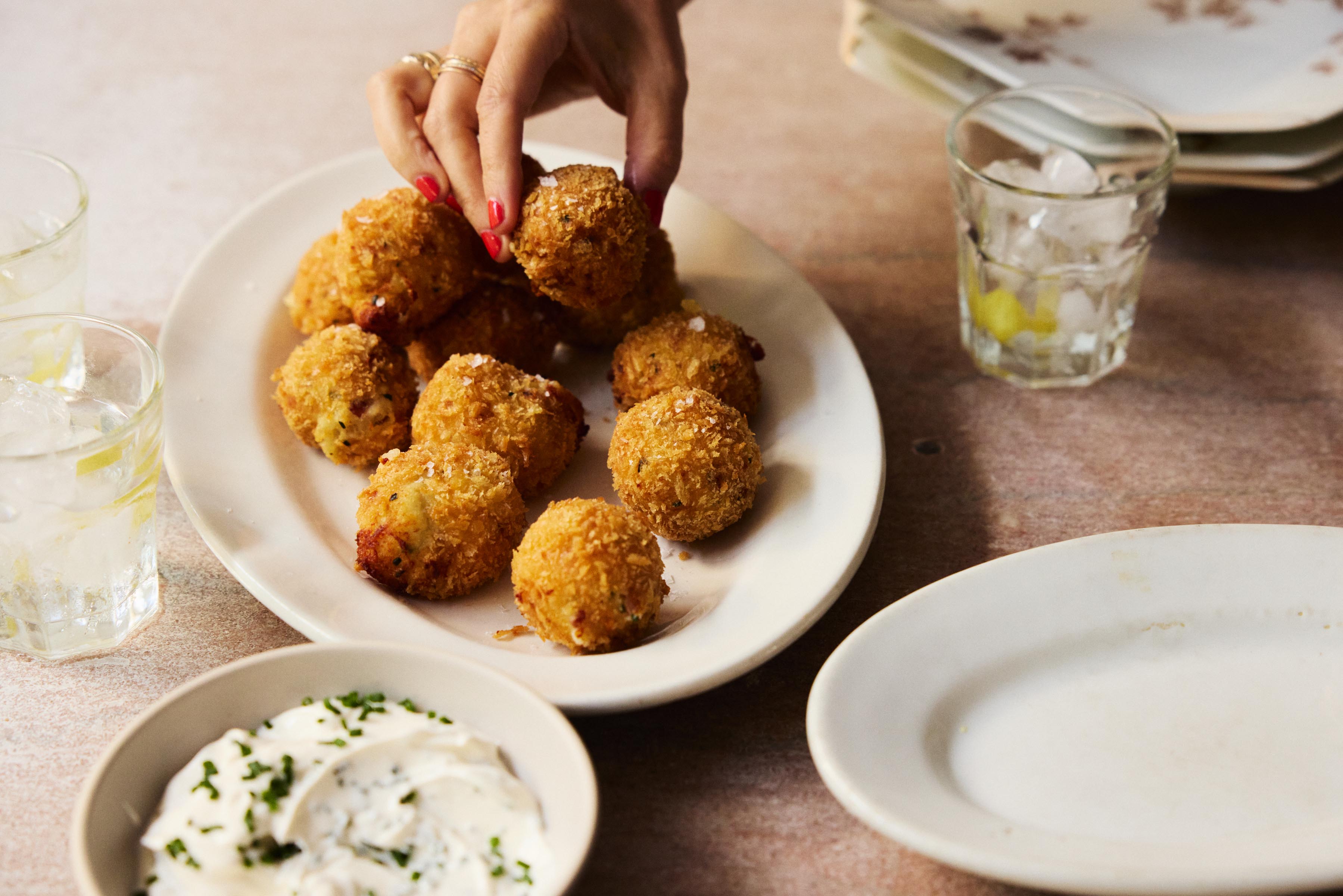 potato and prosciutto croquettes being picked up off a plate