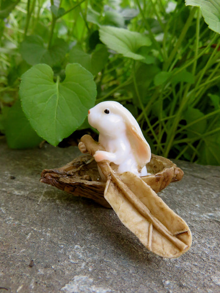 miniature woodland bunny rabbit with paddle in boat-fairy