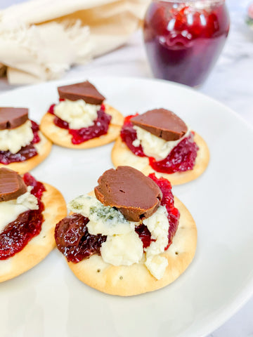 Canape of Water Cracker topped with Sour Cherry Jam, Gorgonzola Dolce, and sliced Deep Chocolate caramel