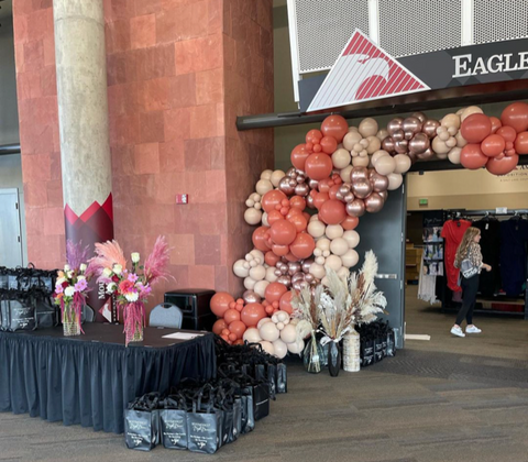 Balloon arch entrance with floral arrangements