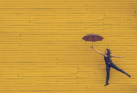 Woman posing against a wall with umbrella
