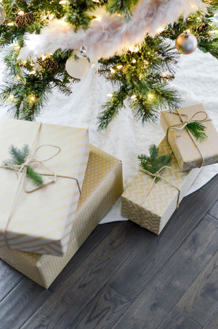 Four gift boxes under a Christmas tree