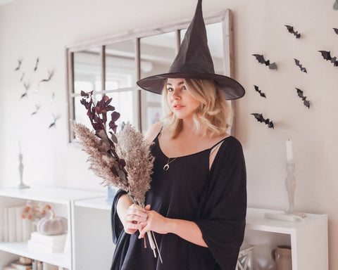 Woman dressed in witch costume with Halloween decorations