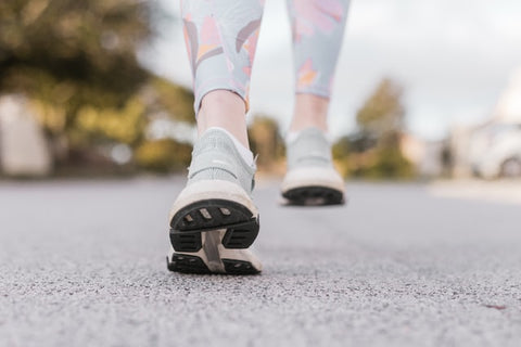 Shot of person's feet with sneakers on pavement