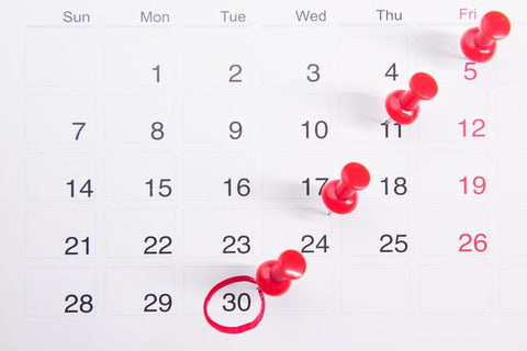 Calendar with red pushpins 