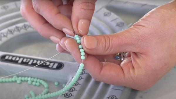 demonstrating an easy way to string beads