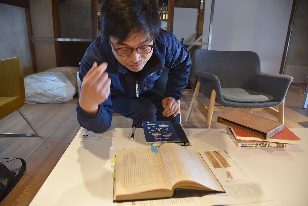 Chobei Yamamoto of Yucho Shuzo in front of old historical sake books