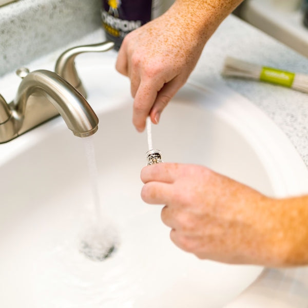 person cleaning glass with pipe cleaner