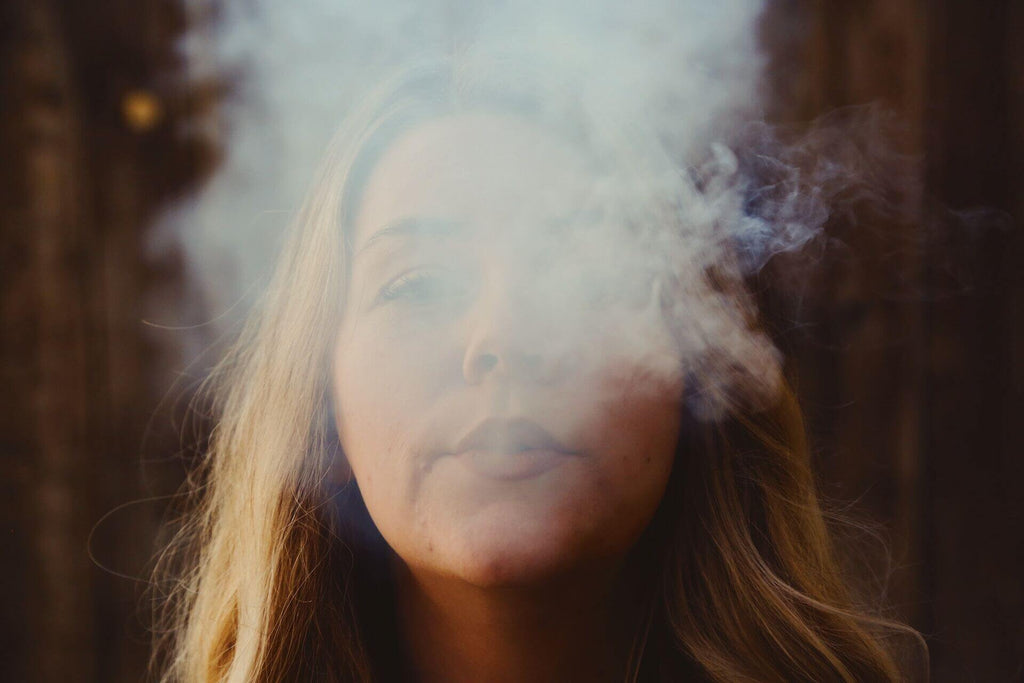 woman blowing smoke in the air