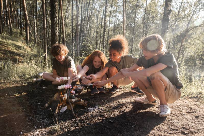 Kids toasting marshmallow on a fire
