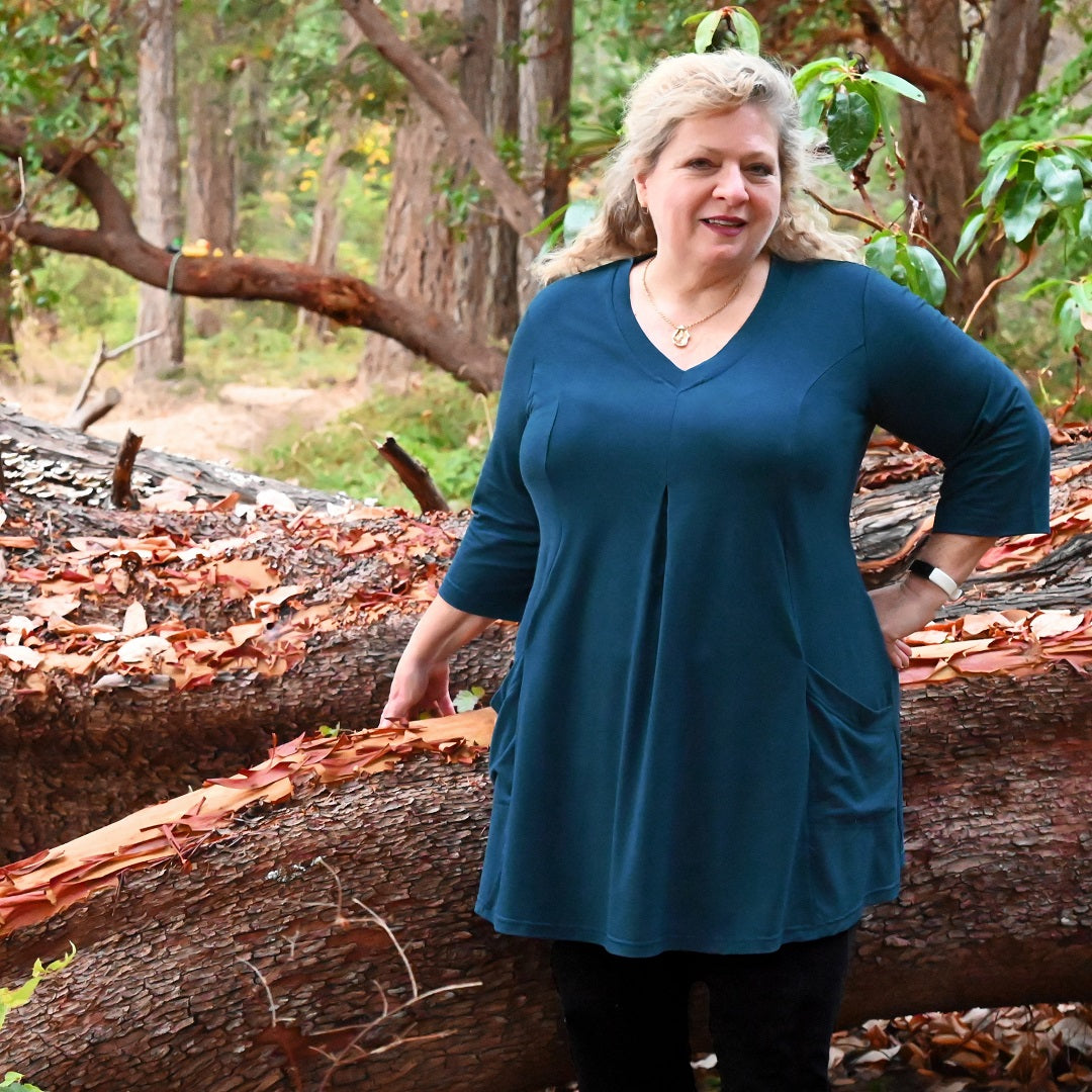 A mature plus size model wears the Playful Tunic by Canadian designer Diane Kennedy in front of an Arbutus tree