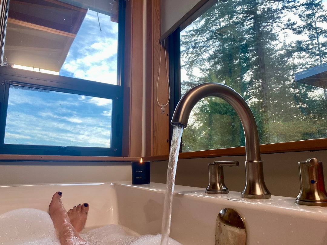 relaxing in a soaker tub with a view of the coastal forest
