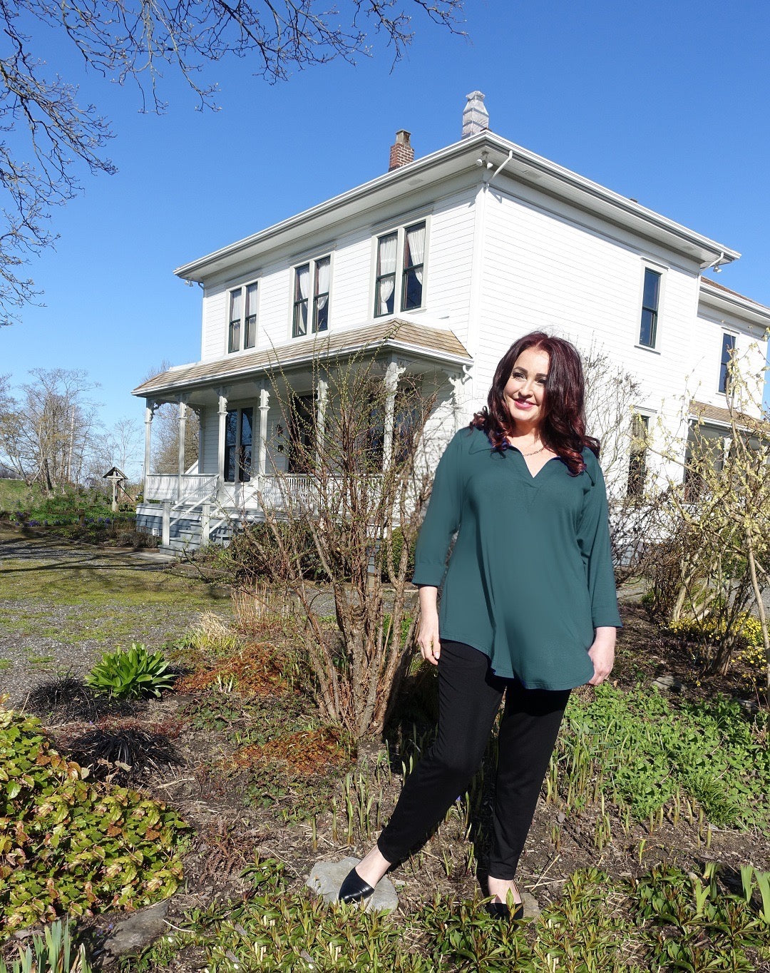 Model wears a Diane Kennedy bamboo shirt in green in front of the Historic London Farmhouse in Steveston BC