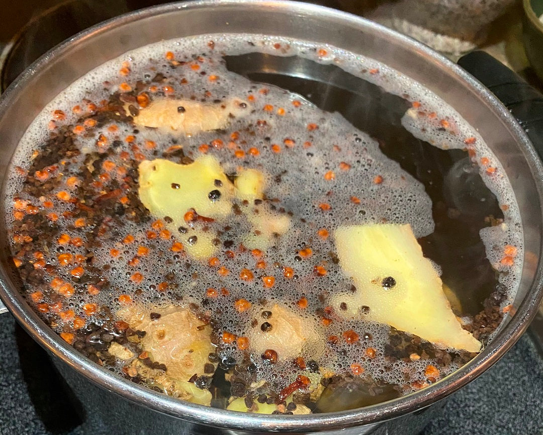 Ingredients for homemade chai tea simmering in a pot