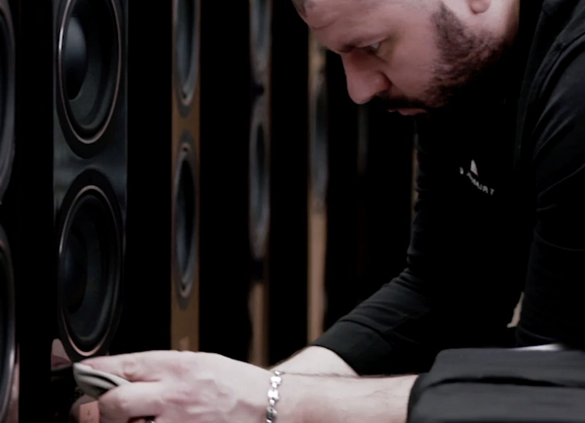 man working on triangle speakers