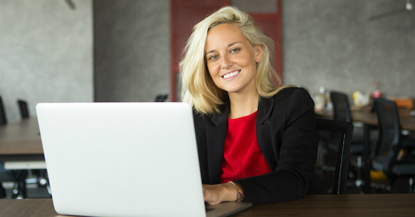 woman with blonde hair typing with laptop