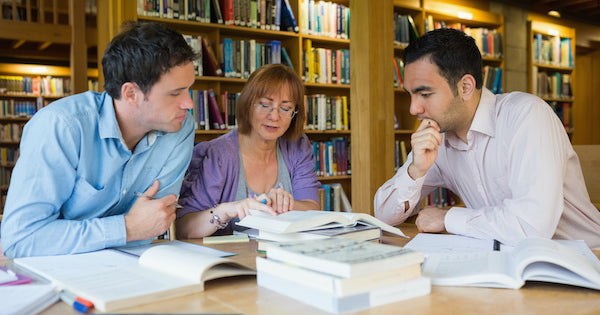 three people reading inside a library