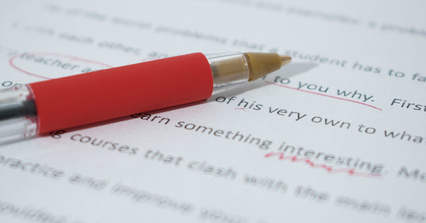 proofreading a paper with a red pen