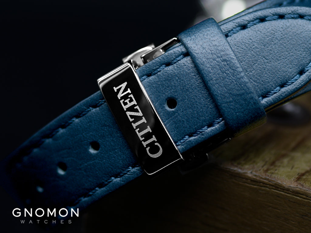 Blue leather strap of the Citizen Silver Leaf Lacquer Dial Blue with a  deployant buckle that bears the Citizen signature
