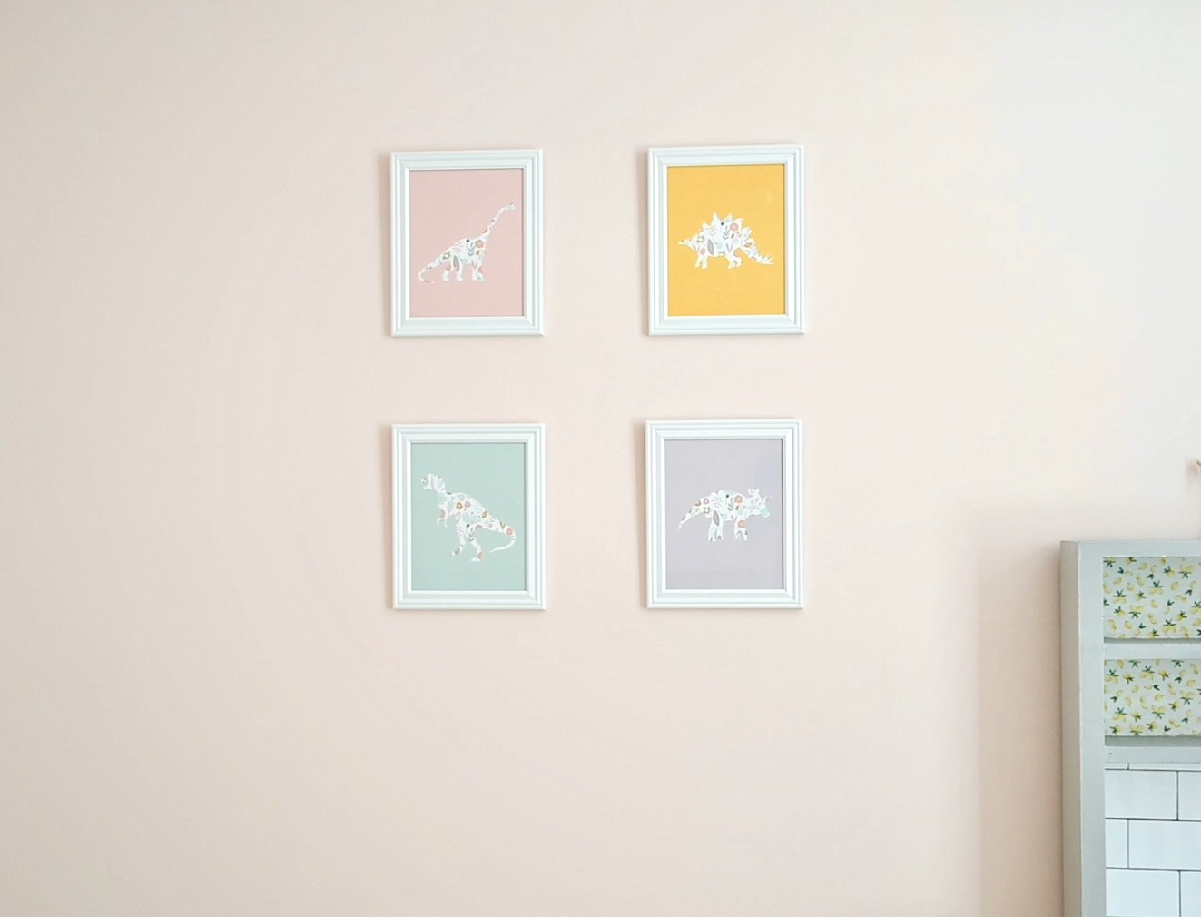 4 colorful dinosaur art prints in white frames