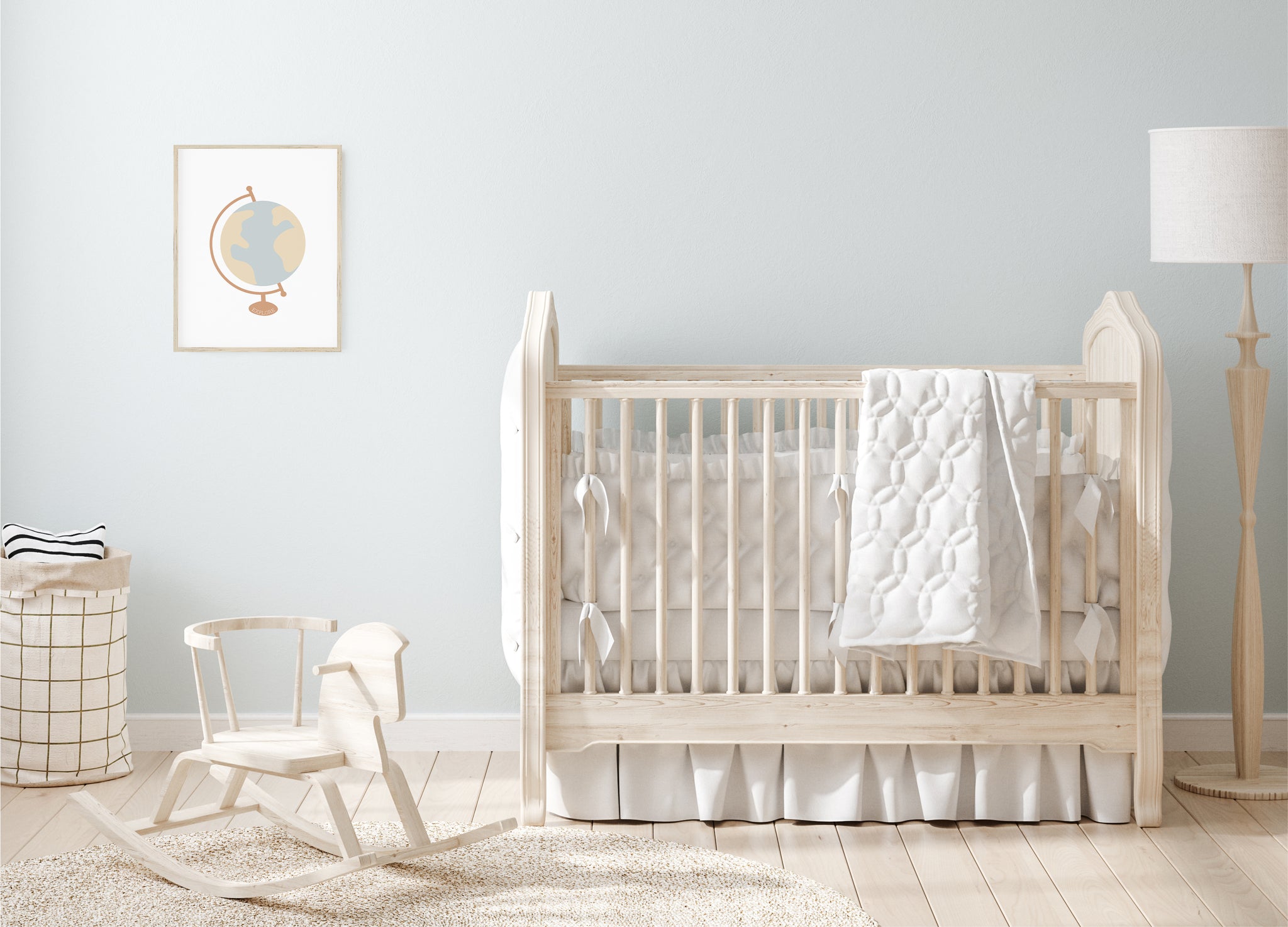 Baby nursery with blue wall, light wood furniture, and globe artwork