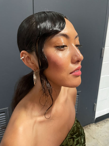 asian fashion model wearing silver hoop earrings and green dress