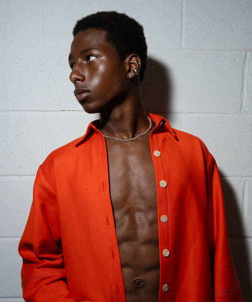 black male model wearing a red shirt and delia langan silver jewelry