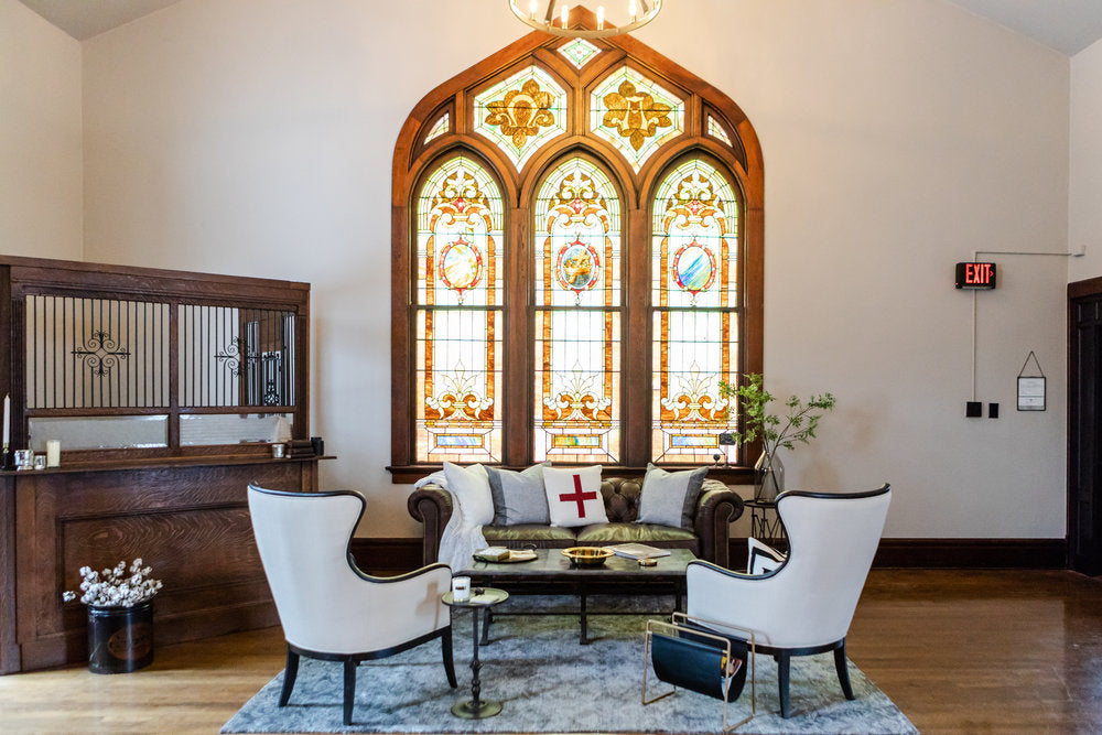 White chairs and couch with stained glass windows