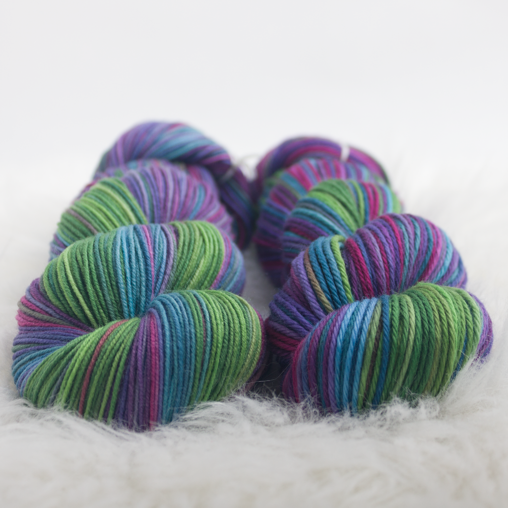 fingering and worsted weight skeins in greens, blues, and purples
