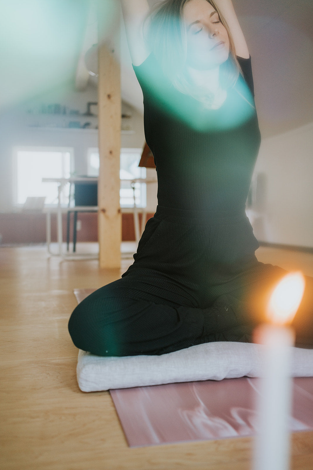 megan stretching on yoga mat with lit candle