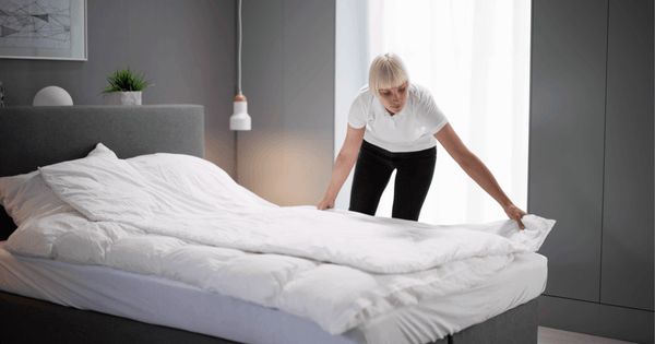 Person smoothing out wrinkles on a duvet for a polished look