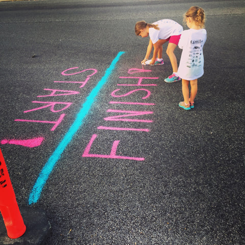 Two children painting a finish line