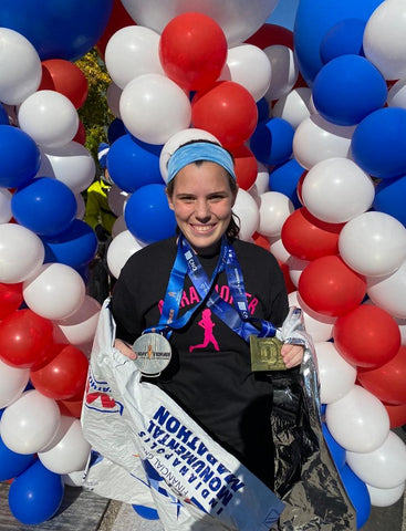 Woman in Ponya Bands Bamboo Terry Lined Sweatband with balloons and medal from marathon