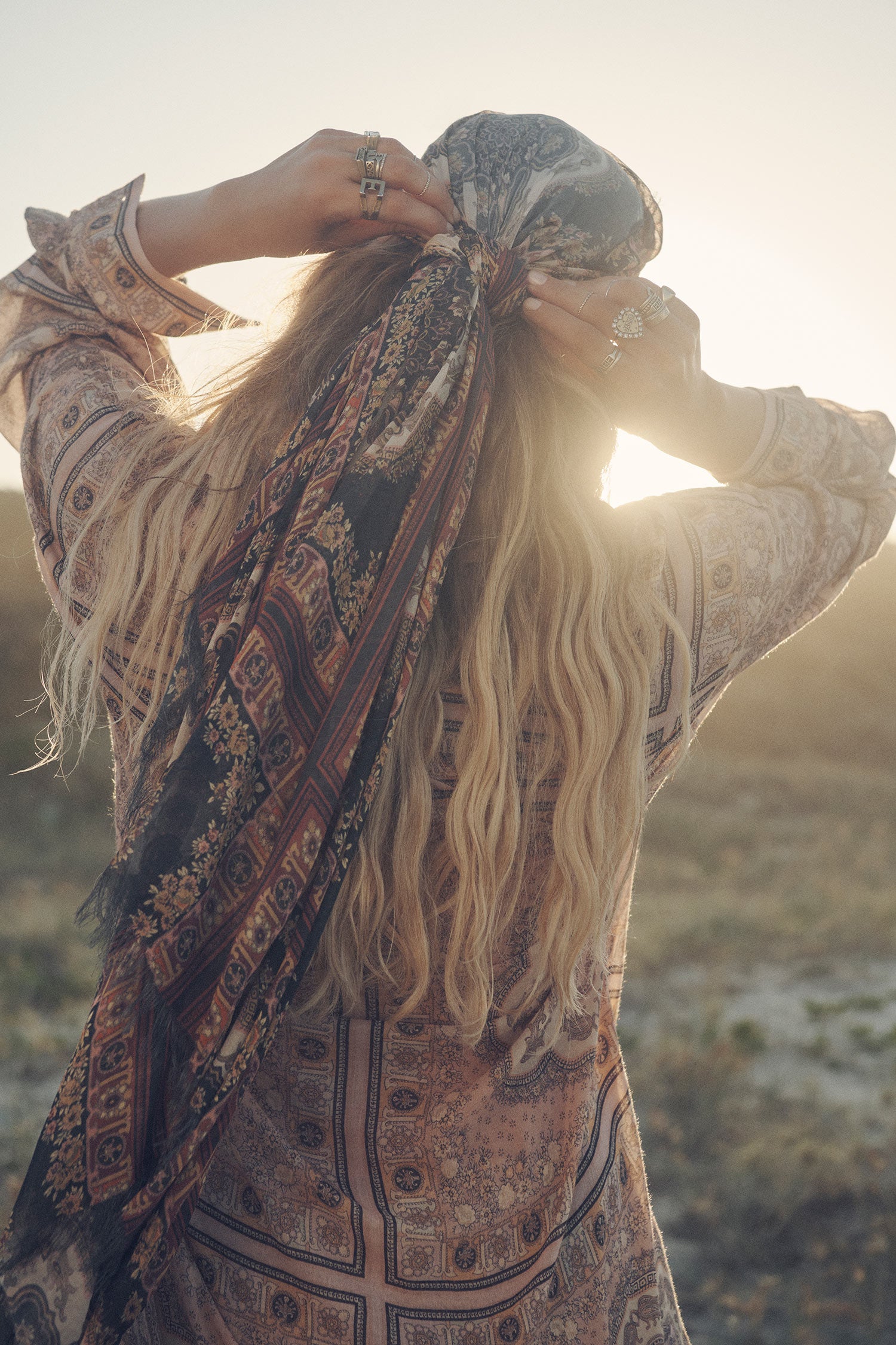 A close-up image of influencer and model, Elle Ferguson, wearing gold jewellery, the Spell Rumour Print Shirt Dress and the Rumour Print Travel Scarf with frayed edges.  