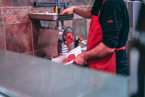 Butcher grinding meat